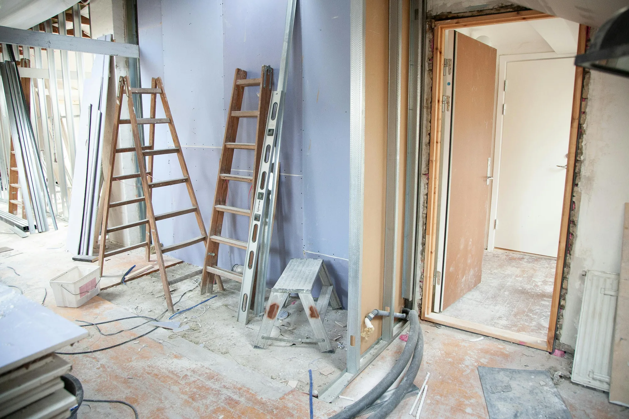 Ruimte in renovatie met ladders en bouwmaterialen